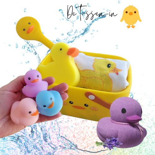 afbeelding van producten met rechtsboven in de tekst 'de grote' en dan een icon van een eend ernaast. afbeelding van een geel eend wasmandje, een eenden spons, een eenden borstel, een eenden handdoekje, een hand met 3 rubberen eendjes in de kleuren pastel blauw, roze en paars en een paarse eenden bad bruisbal. Op de achtergrond is een water splash zichtbaar en regenboog glitter.